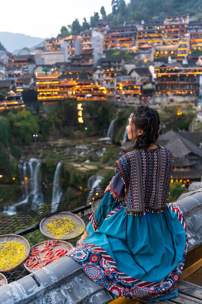 Mujer disfrutando de un atardecer mientras observa la ciudad de iljiang